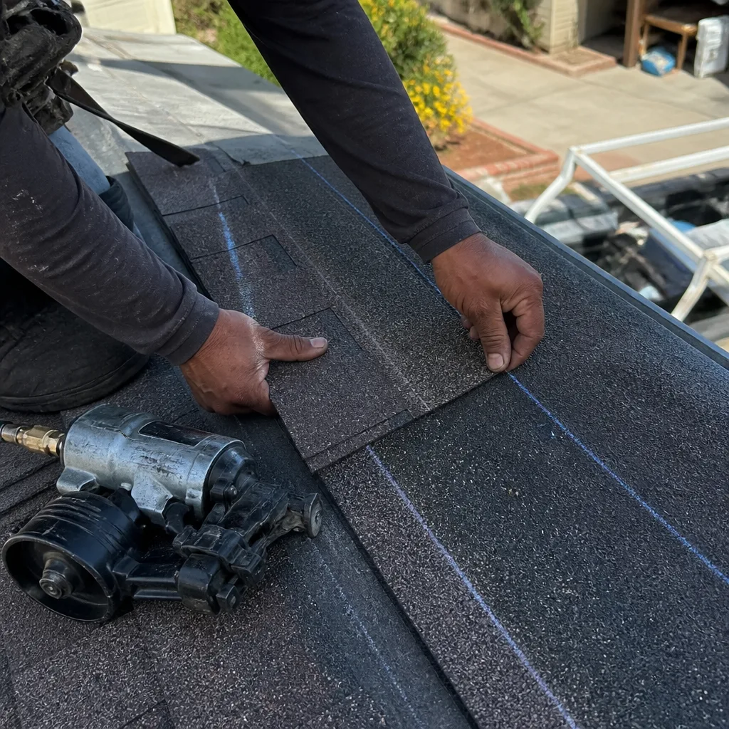 Professional roofer installing shingles on a residential roof